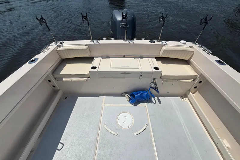 Slide: The Image of 1999 Grady-White Tournament 225 boat interior with seating and fishing rod holders. - 17