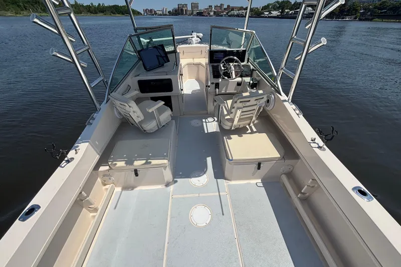Slide: The Image of 1999 Grady-White Tournament 225 boat interior with seating and steering wheel on calm water. - 19
