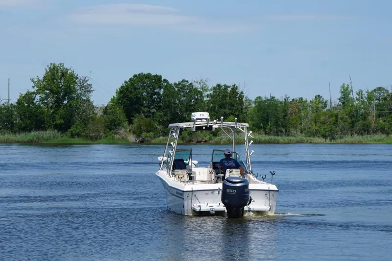 Slide: The Image of 1999 Grady-White Tournament 225 boat cruising on a calm lake with trees in the background. - 10