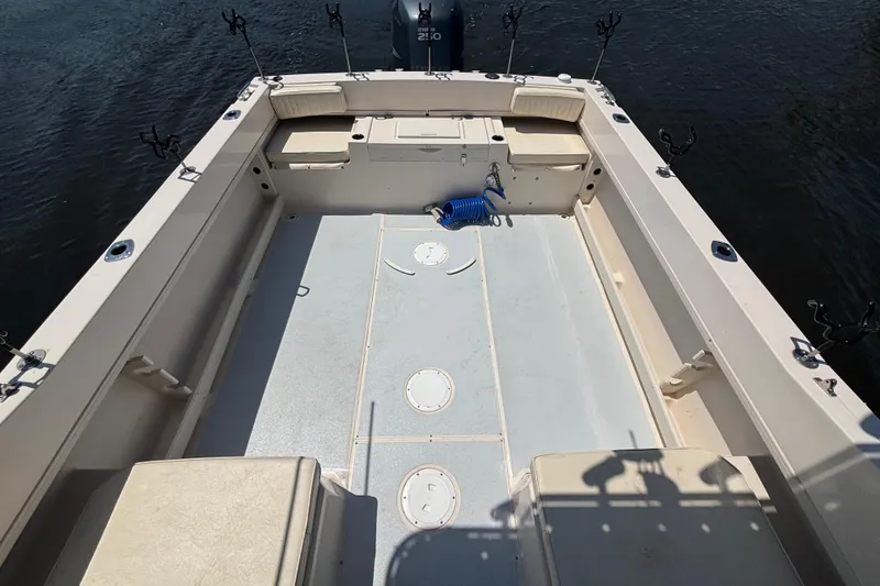 Slide: The Image of 1999 Grady-White Tournament 225 boat deck with fishing rod holders and storage compartments. - 16