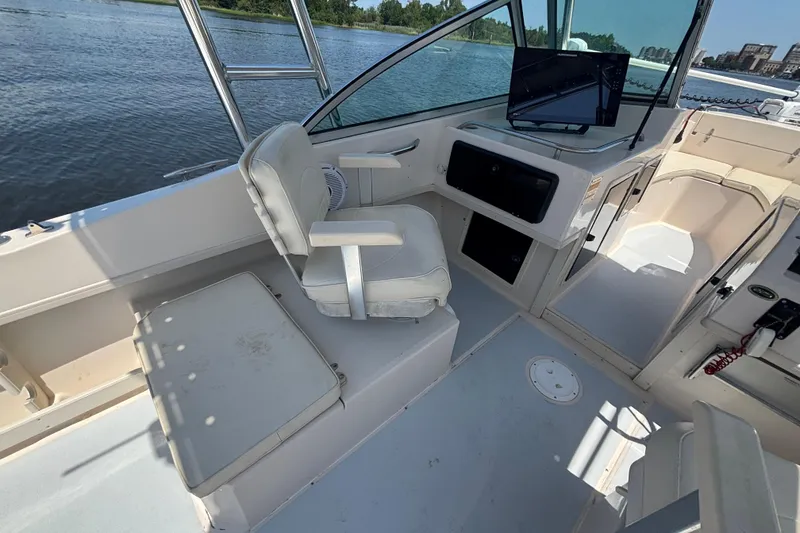 Slide: The Image of 1999 Grady-White Tournament 225 boat interior with seating and control panel by the water. - 21