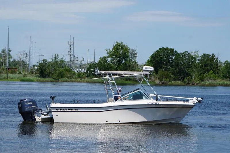 Slide: The Image of 1999 Grady-White Tournament 225 boat on a calm river with lush green background. - 6
