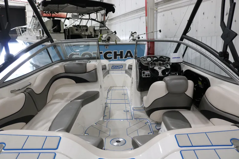 Slide: The Image of 2009 Yamaha Boats 212X interior with seating and dashboard in a showroom. - 5