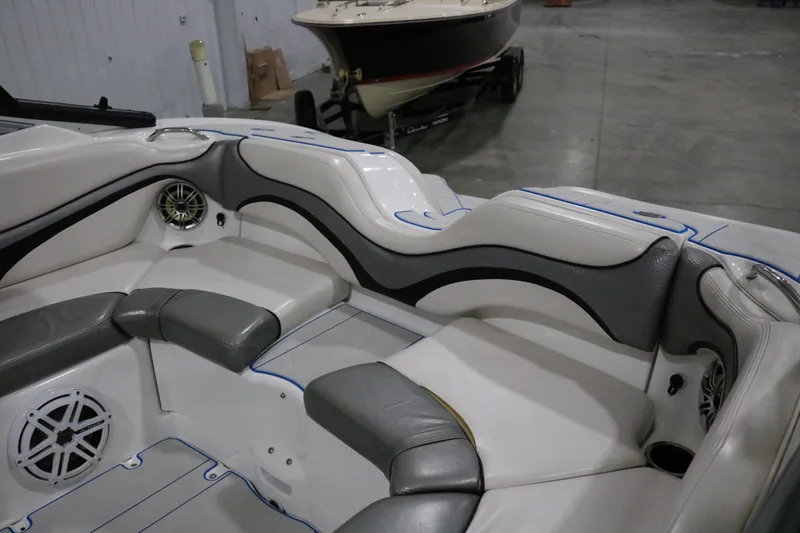 Slide: The Image of 2009 Yamaha Boats 212X interior with gray and white seating, speaker, and cup holder. - 33