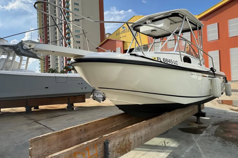 Slide: The Image of 1999 Boston Whaler 21 Conquest boat on dry dock, with urban buildings in background. - 1