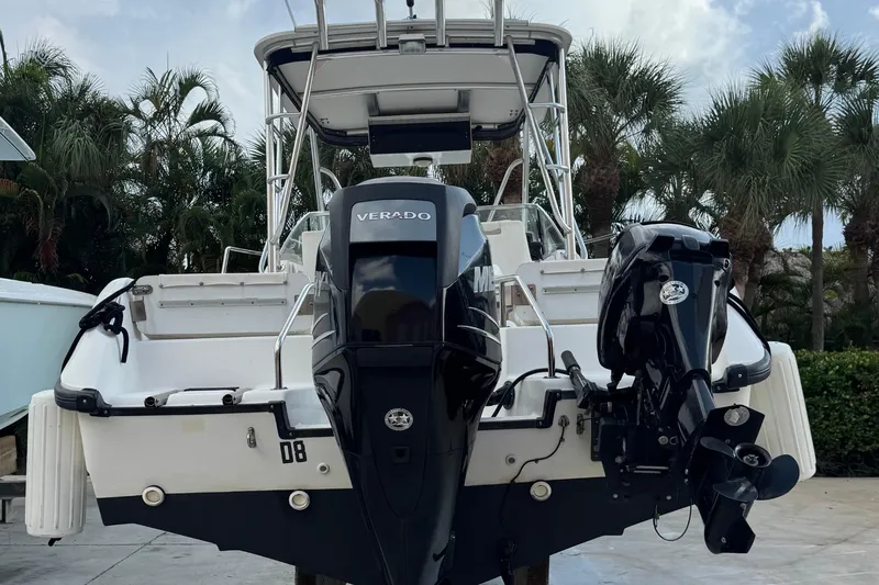 Slide: The Image of 1999 Boston Whaler 21 Conquest boat with Verado outboard motor, parked near palm trees. - 4