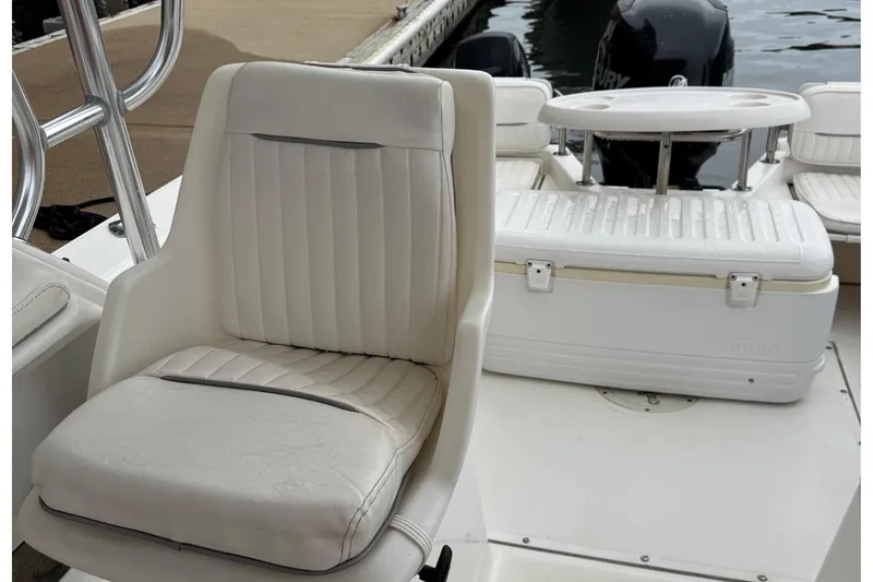 Slide: The Image of 1999 Boston Whaler 21 Conquest boat interior with white seating and engine view. - 6
