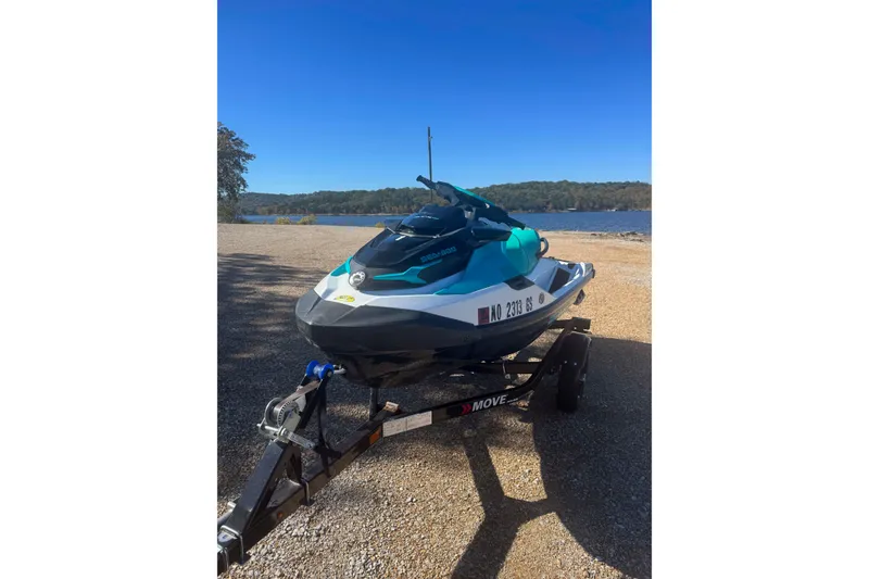 Slide: The Image of 2022 Sea-Doo GTI SE 130 jet ski on trailer by a lake. - 1