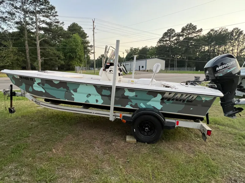 The Image of 2013 Mako Pro 17 with camouflage pattern, on a trailer, featuring a Mercury outboard motor. - 0
