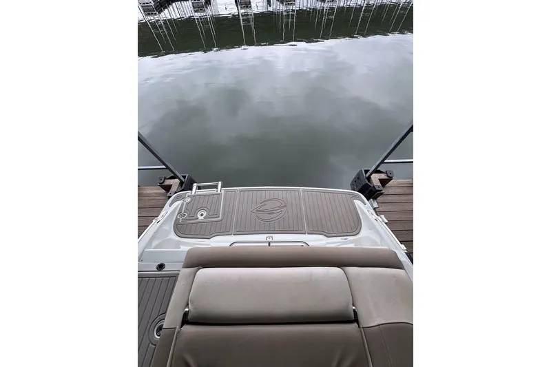 Slide: The Image of 2019 Crownline 215 SS boat stern view at dock, calm water reflection. - 15