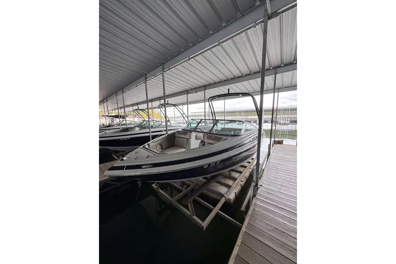 Slide: The Image of 2019 Crownline 215 SS boat docked under a covered marina. - 3