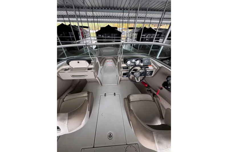 Slide: The Image of Interior view of 2019 Crownline 215 SS boat, featuring steering wheel and seating. - 7