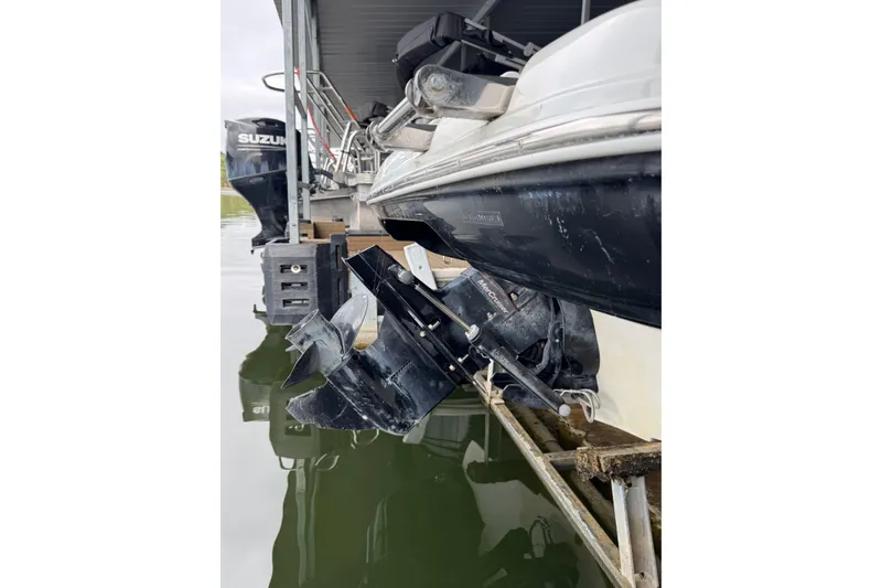 Slide: The Image of 2019 Crownline 215 SS boat with visible outboard motor and propeller in marina. - 16