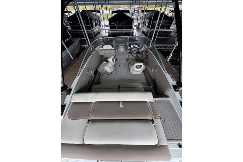 Slide: The Image of 2019 Crownline 215 SS boat interior with seating and dashboard in a marina. - 6