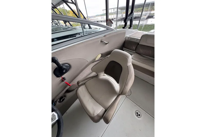 Slide: The Image of 2019 Crownline 215 SS boat interior with beige seating and steering controls. - 13