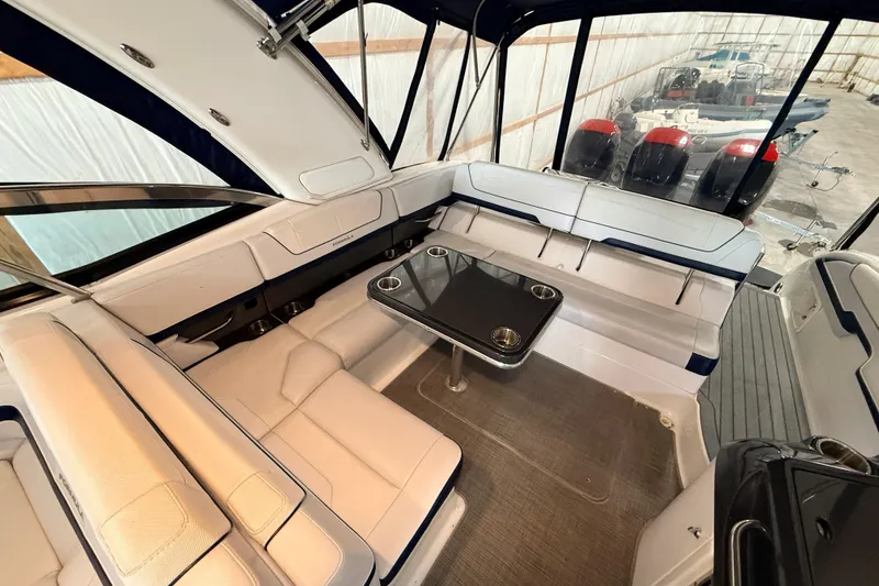 Slide: The Image of 2017 Formula 350 Crossover Bowrider OB interior with seating and table in a boat garage. - 24