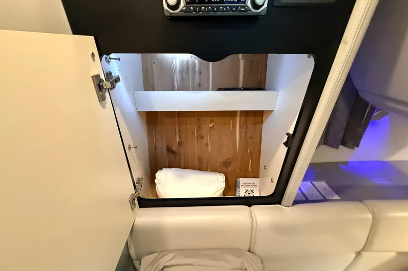 Slide: The Image of 2017 Formula 350 Crossover Bowrider OB cabin storage with wooden interior and white cushions. - 41