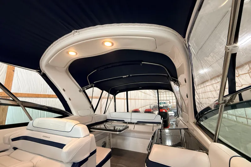 Slide: The Image of 2017 Formula 350 Crossover Bowrider OB interior with seating and canopy in a storage facility. - 43