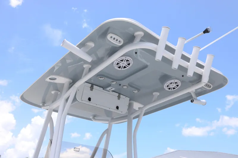 Slide: The Image of T-top of 2027 Sea Hunt Ultra 219 boat with rod holders and speakers against blue sky. - 3