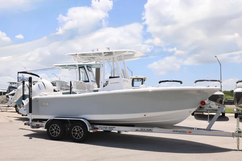 Slide: The Image of 2027 Sea Hunt Ultra 219 boat on trailer under a bright blue sky. - 9