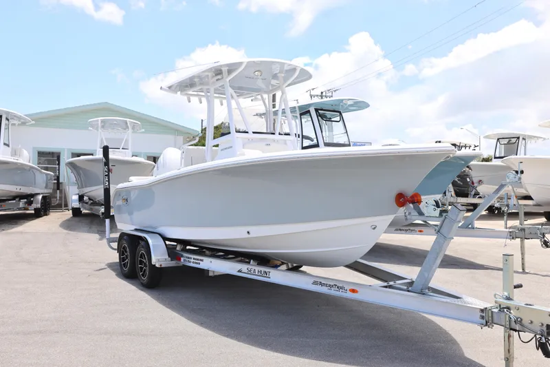 Slide: The Image of 2027 Sea Hunt Ultra 219 boat on trailer, displayed outdoors under a clear sky. - 14