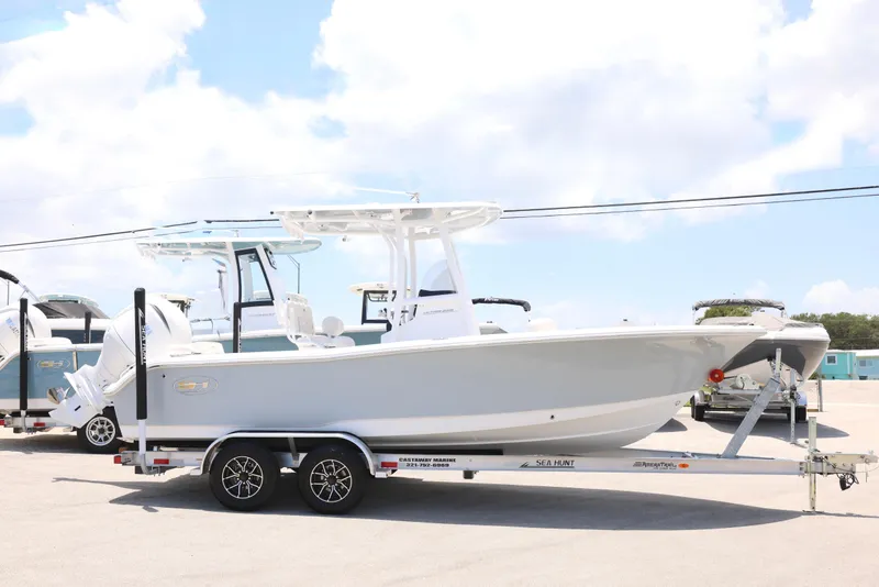 Slide: The Image of 2027 Sea Hunt Ultra 219 boat on trailer under clear sky. - 15