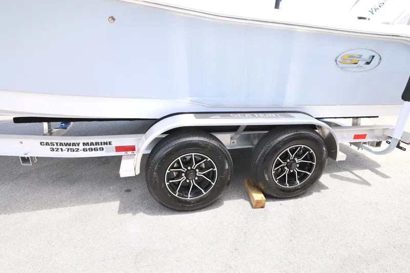 Slide: The Image of Trailer with 2027 Sea Hunt Ultra 219 boat, featuring dual black alloy wheels. - 11