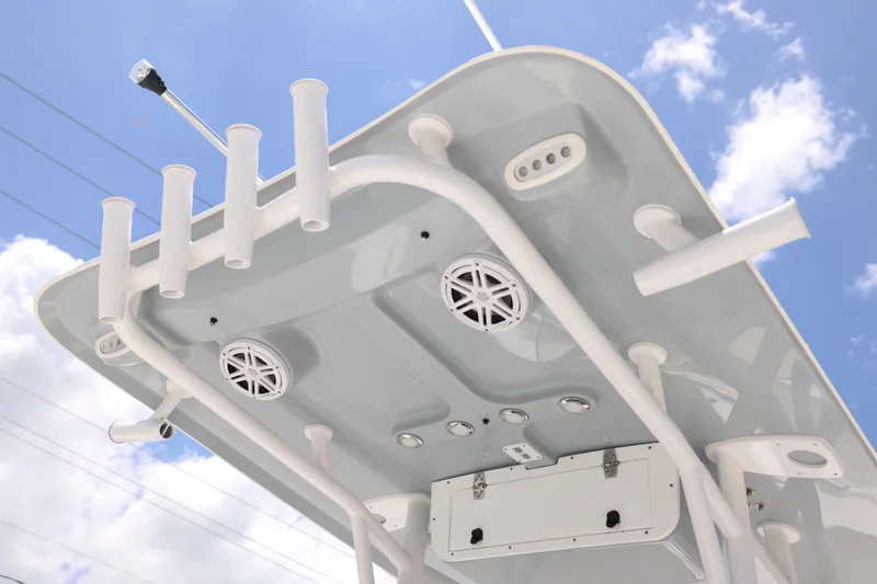 Slide: The Image of 2027 Sea Hunt Ultra 219 boat top view with rod holders and speakers against blue sky. - 27