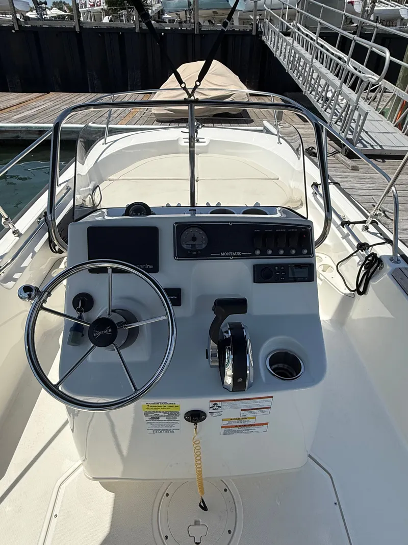 Slide: The Image of The image shows the helm of a 2022 Boston Whaler 170 Montauk with steering wheel and instruments. - 8