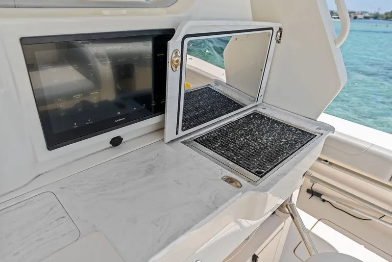 Slide: The Image of 2021 Scout 425 LXF boat interior with control panel and open storage compartment. - 23