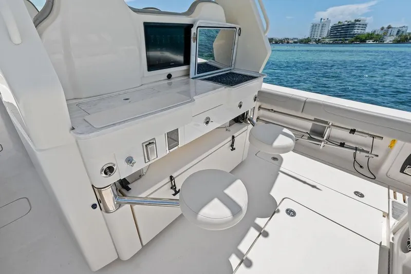 Slide: The Image of 2021 Scout 425 LXF boat interior with seating and control panel by the water. - 22