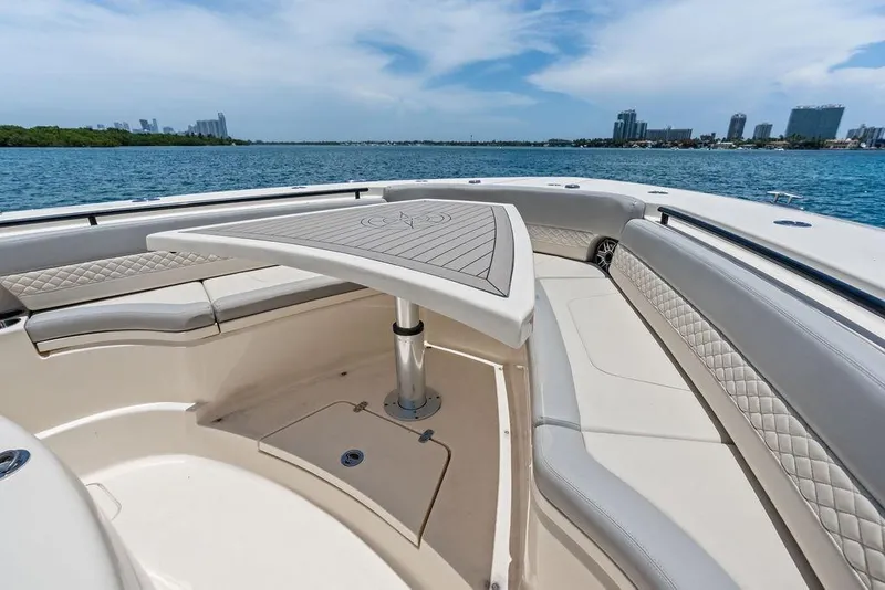 Slide: The Image of 2021 Scout 425 LXF boat interior with seating and table, overlooking city skyline. - 16
