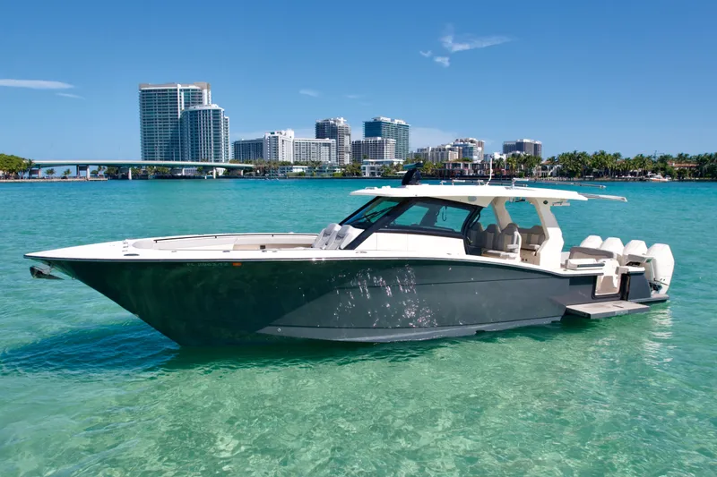 The Image of 2021 Scout 425 LXF boat on turquoise water with city skyline background. - 0