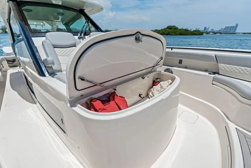 Slide: The Image of 2021 Scout 425 LXF boat with open storage compartment, docked near water. - 19