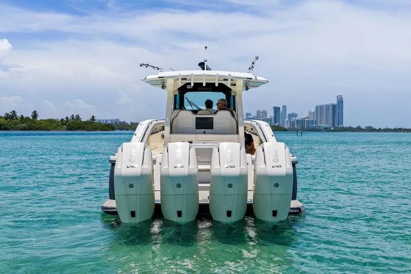 Slide: The Image of 2021 Scout 425 LXF boat with four engines on turquoise water, city skyline in background. - 3