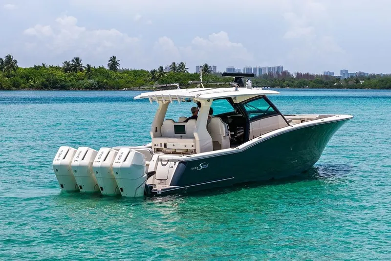 Slide: The Image of 2021 Scout 425 LXF boat with four engines on turquoise water, tropical backdrop. - 1