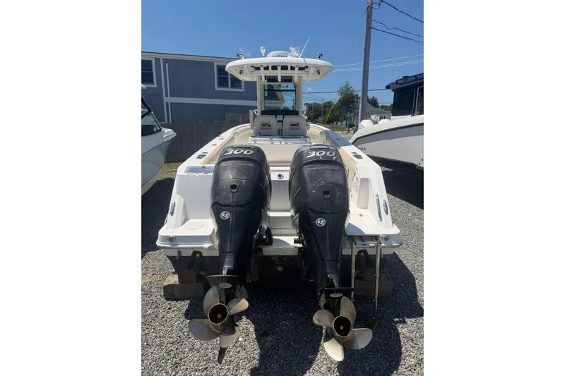 Slide: The Image of 2016 Boston Whaler 280 Outrage with dual 300 horsepower engines, parked on gravel. - 3