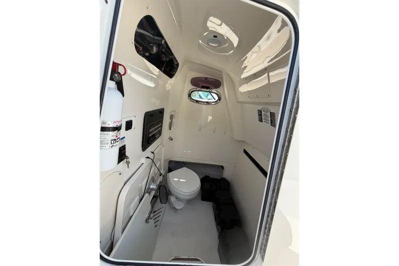 Slide: The Image of Interior of 2016 Boston Whaler 280 Outrage boat, featuring a compact marine toilet. - 8