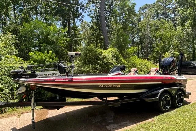 Slide: The Image of 2022 Skeeter FXR21 Limited boat on trailer in wooded area. - 3