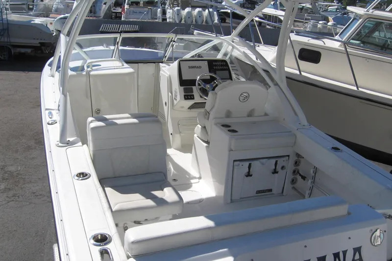 Slide: The Image of 2019 Edgewater 248CX Crossover boat interior with helm, seating, and storage compartments. - 7