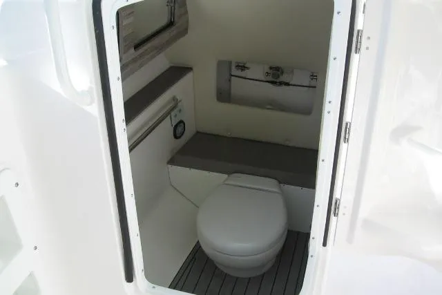 Slide: The Image of 2019 Edgewater 248CX Crossover boat interior with compact marine toilet. - 3