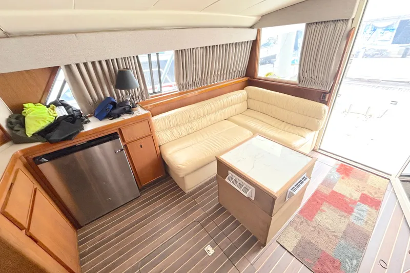 Slide: The Image of Interior of a 1990 Bertram 37 Convertible yacht with beige seating and wooden accents. - 17