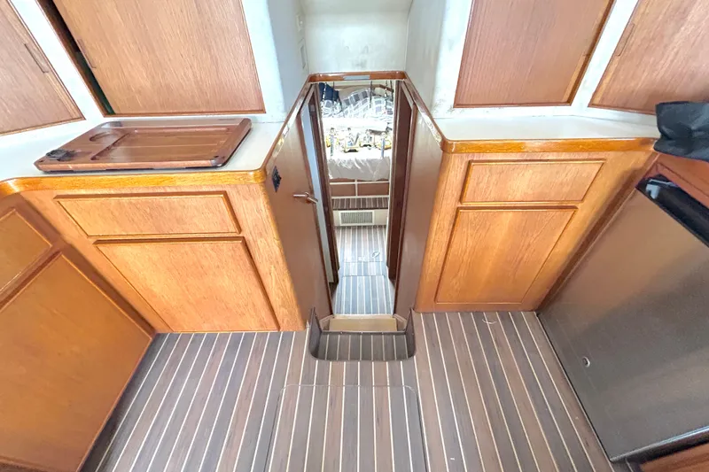 Slide: The Image of Interior of 1990 Bertram 37 Convertible yacht with wooden cabinetry and striped flooring. - 22