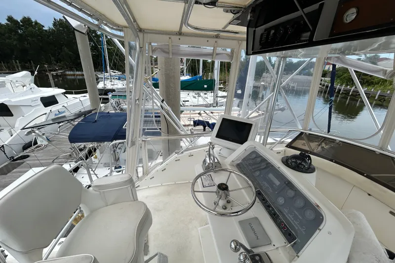 Slide: The Image of Cockpit view of a 1990 Bertram 37 Convertible yacht at a marina. - 9