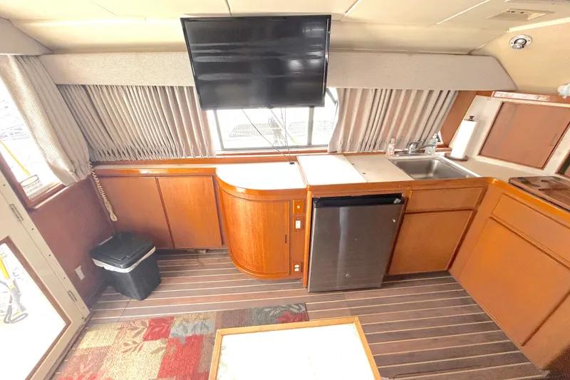 Slide: The Image of Interior of a 1990 Bertram 37 Convertible yacht with kitchenette and TV. - 20