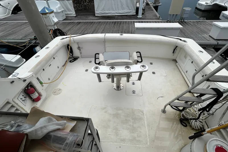 Slide: The Image of 1990 Bertram 37 Convertible boat deck with fishing chair and dock view. - 7