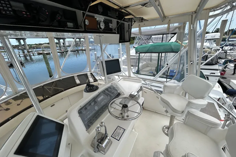 Slide: The Image of Cockpit of a 1990 Bertram 37 Convertible yacht with steering wheel and navigation equipment. - 11