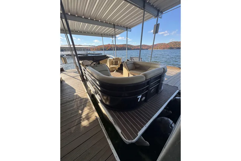 Slide: The Image of 2020 Crest Classic LX 220 L pontoon boat docked on a scenic lake. - 2