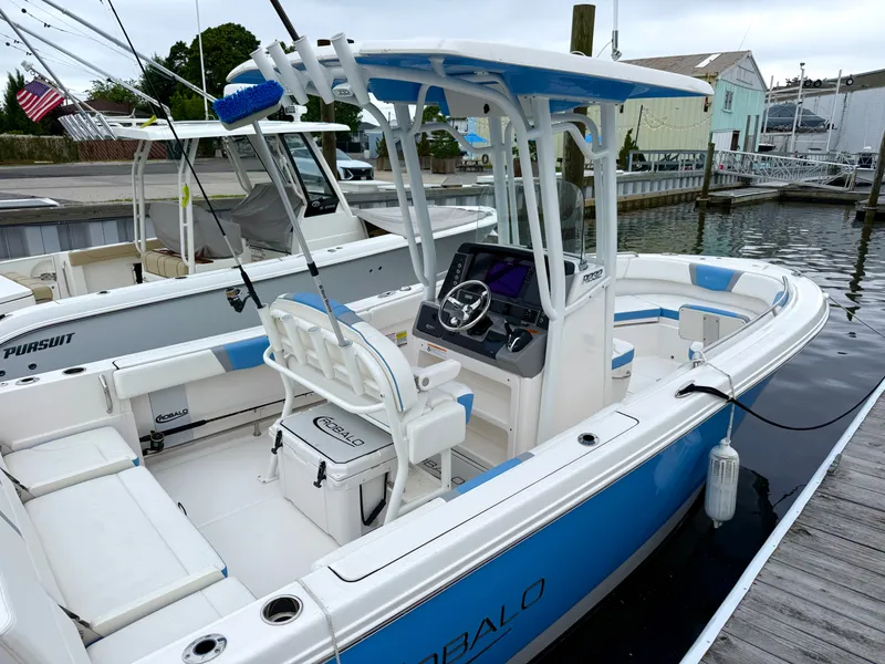 Slide: The Image of 2025 Robalo R232 Explorer: A sport boat with blue and white design, spacious cockpit, and modern helm. - 2
