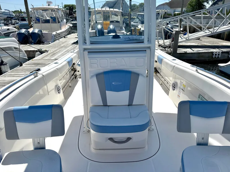 Slide: The Image of Robalo R232 Explorer 2025: A modern boat with blue and white seats, docked at a marina. - 11